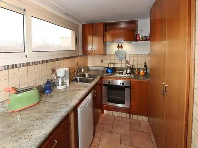 a small kitchen with wooden cabinets and a sink at Angelo Emo Terrace in Rome