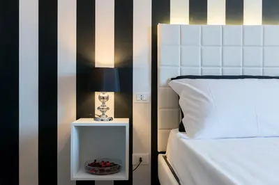 a bed with a lamp and a bowl of fruit on a night stand at Residenza Edoardo I in Rome