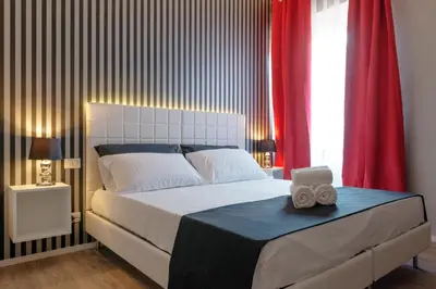 a bedroom with a large bed with red curtains at Residenza Edoardo I in Rome