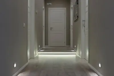 an empty hallway with a white door and wooden floors at Residenza Edoardo I in Rome