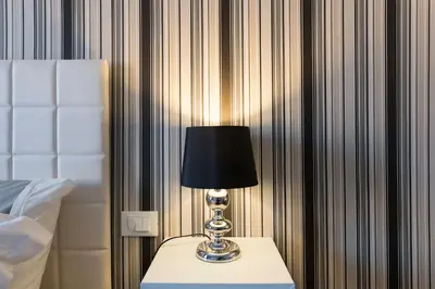 a lamp sitting on a table next to a bed at Residenza Edoardo I in Rome