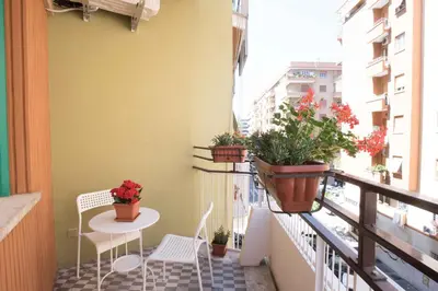 a balcony with a table and chairs and potted plants at Audrey Rooms in Rome