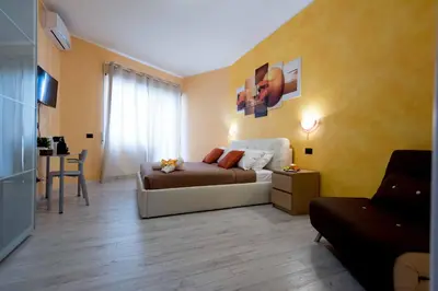 a bedroom with a bed and a table with a chair at Audrey Rooms in Rome