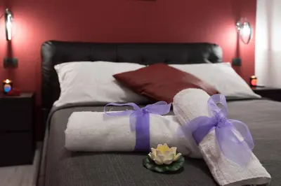 a bed with towels and purple bows on it at Audrey Rooms in Rome