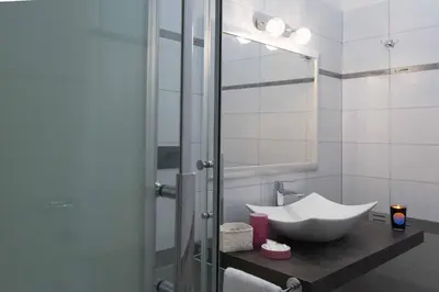 a bathroom with a sink and a glass shower at Audrey Rooms in Rome