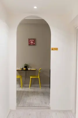 a hallway with a yellow chair and a table at Audrey Rooms in Rome