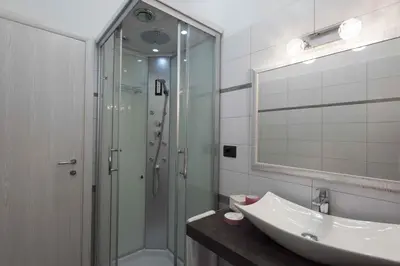 a bathroom with a glass shower and a sink at Audrey Rooms in Rome