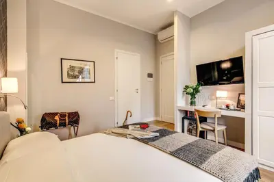 a bedroom with a bed and a desk and a tv at The Club Navona in Rome