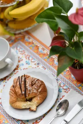 a pastry on a plate on a table with bananas at Hotel Bella Vita in Rome