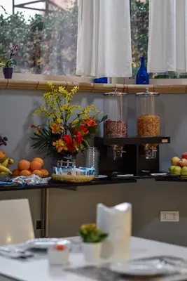 a shelf with flowers and other food items on it at Hotel Bella Vita in Rome