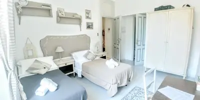 a bedroom with two beds and a desk and a table at B&B Next Stop in Rome