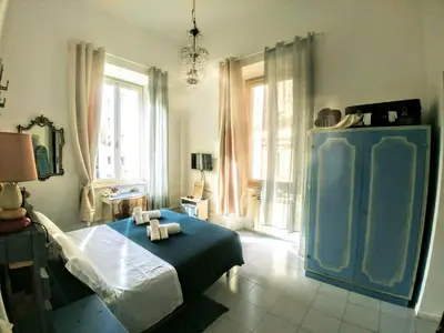 a bedroom with a blue bed in a room with windows at B&B Next Stop in Rome