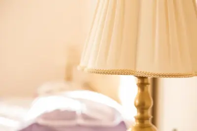 a close up of a gold lamp with a white lamp shade at Villa Matissa in Rome