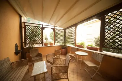 a balcony with chairs and tables and windows at Villa Matissa in Rome