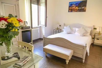 a bedroom with a white bed and a vase of flowers at Villa Matissa in Rome