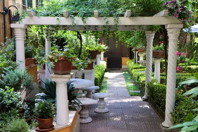 an outdoor pergola with benches and potted plants at Villa Matissa in Rome