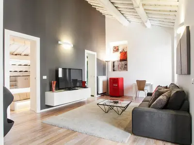 a living room with a couch and a tv at Spanish Steps Luxury Penthouse in Rome