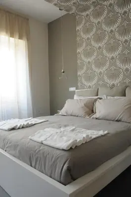 a large white bed in a room with a window at Alma Mater B&B in Rome