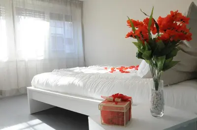 a bedroom with a bed with a vase of flowers on a table at Alma Mater B&B in Rome