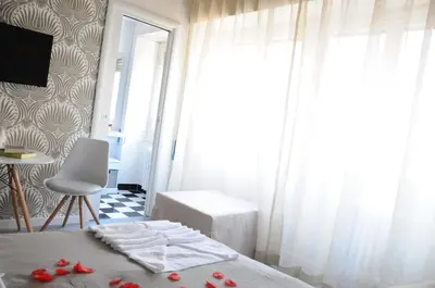 a bedroom with a bed and a window with red flowers on it at Alma Mater B&B in Rome