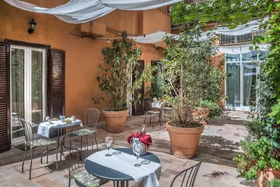 a patio with tables and chairs and plants at Ingrami Suites and Spa in Rome