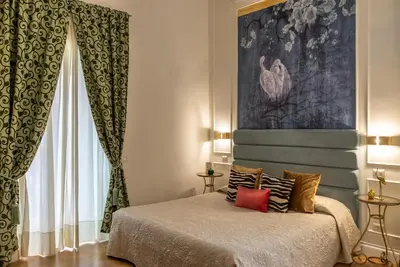 a bedroom with a bed and a painting on the wall at Ingrami Suites and Spa in Rome