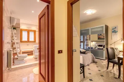 a bathroom with a toilet and a bedroom at Residenza Amoroma in Rome