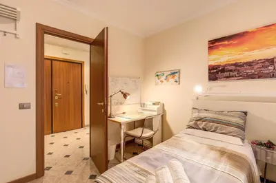a bedroom with a bed and a desk at Residenza Amoroma in Rome