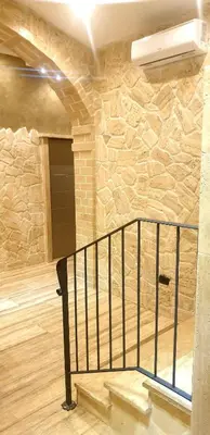 a room with a stone wall and a staircase at Jadore Monic in Rome