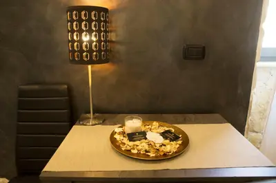 a table with a candle and a plate of food on it at Jadore Monic in Rome