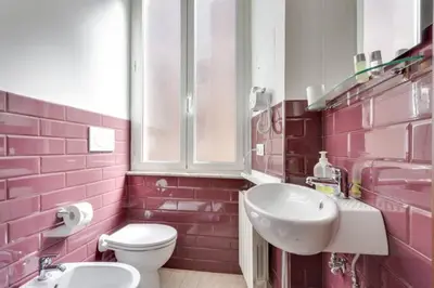 a pink bathroom with a sink and a toilet at B&B Gallia's Rooms in Rome