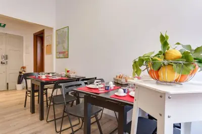 a dining room with tables and chairs and a bowl of fruit at B&B Gallia's Rooms in Rome