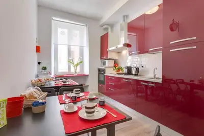 a kitchen with red cabinets and a table with dishes on it at B&B Gallia's Rooms in Rome