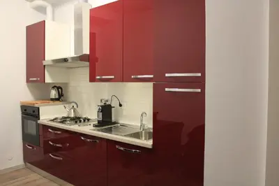 a kitchen with red cabinets and a sink at B&B Gallia's Rooms in Rome