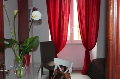 a room with red curtains and a table and a window at B&B Gallia's Rooms in Rome