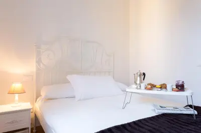 a bedroom with a white bed with a side table at TownHouse by the Spanish Steps in Rome