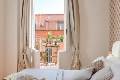 a living room with a white couch and an open window at TownHouse by the Spanish Steps in Rome