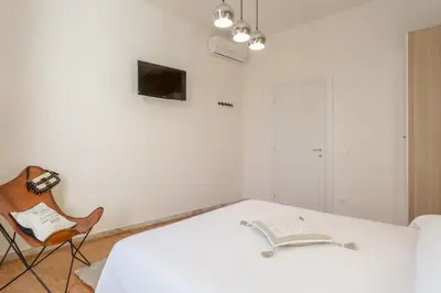 a white room with a bed and a chair at TownHouse by the Spanish Steps in Rome