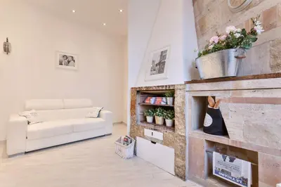 a living room with a white couch and a fireplace at TownHouse by the Spanish Steps in Rome