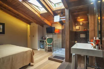 a bedroom with a bed and a bathroom with a sink at Etruria Relais in Rome