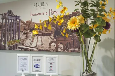 a vase of flowers sitting on a table with a sign at Etruria Relais in Rome