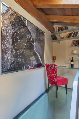 a red chair in a room with a painting on the wall at Etruria Relais in Rome