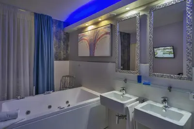 a bathroom with two sinks and a tub and two mirrors at Etruria Relais in Rome