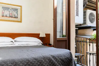a bedroom with a bed and a balcony at Domus Julia Trevi - Spagna in Rome