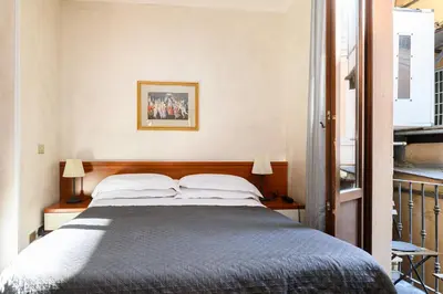 a bedroom with a large bed with two lamps at Domus Julia Trevi - Spagna in Rome