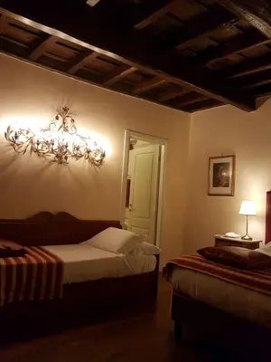 a bedroom with two beds and a chandelier on the wall at Domus Julia Trevi - Spagna in Rome