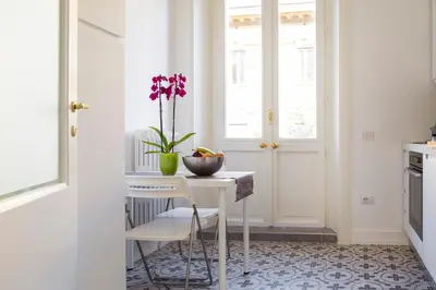 a kitchen with a table with a vase of flowers on it at Casa Tommasina in Rome