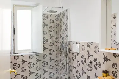 a bathroom with a shower with gray and white wallpaper at Casa Tommasina in Rome