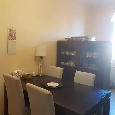 a dining room table with white chairs and a black table at Dante in Rome