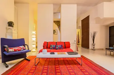a living room with a red couch and a blue chair at Rome as you feel - Selci Apartment in Rome